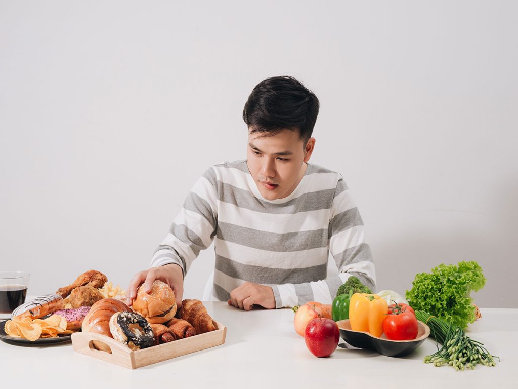 Man Choosing Unhealthy Food over Healthy Ones